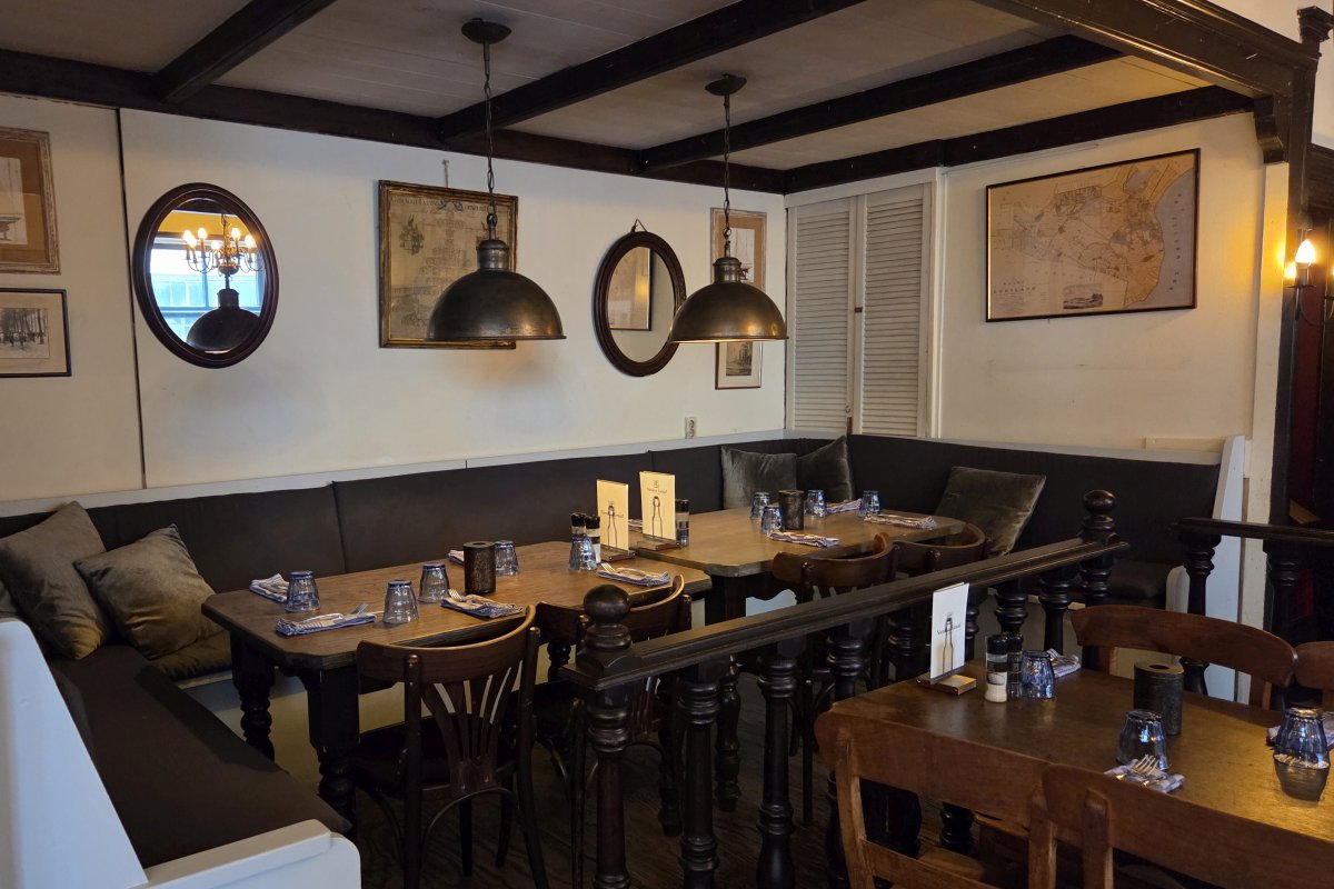 Gezellige, intieme zithoek in restaurant De Nieuwe Graaf in Hilversum, met vintage inrichting, warme verlichting en sfeervolle details. Ideaal voor een diner met een groep.